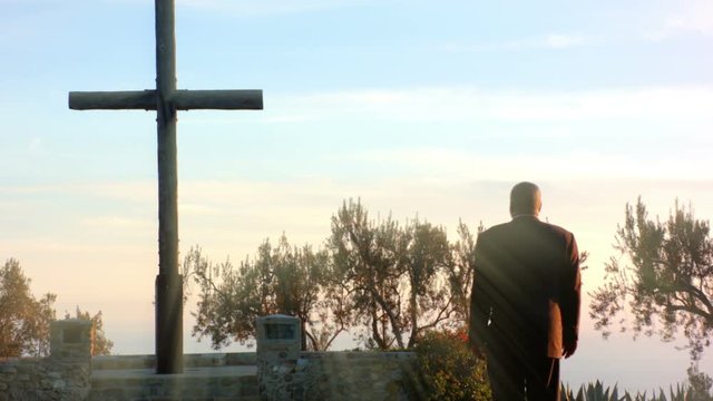 African American Black Male looks at large cross outside
