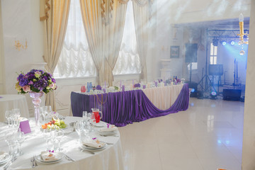 Sunshine illuminates a restaurant hall decorated in violet tones