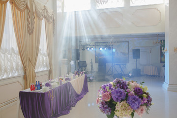 Sun shines through the windows on a white restaurant hall