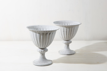 Two old white Greek flowerpots on the white background