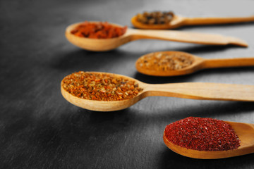 Spices in wooden spoons on a dark background