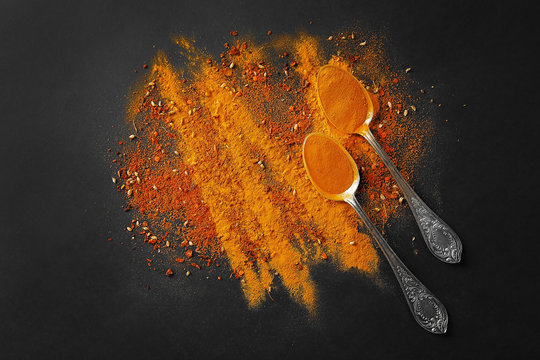 Spices in  spoons on a dark background