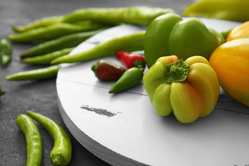 Different sorts of pepper on wooden tray