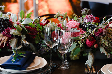 Crystal glassware stands behind a dinner plate with blue serviet