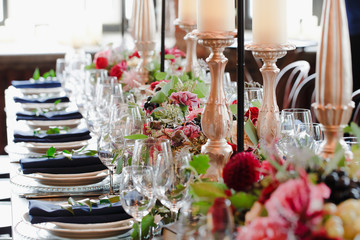 Sparkling glassware stand on the table among flower bouquets