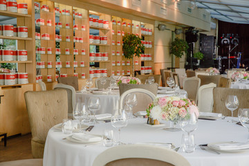 White round tables served for a festive dinner stand in a restau