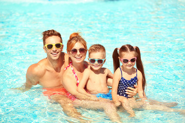 Happy family in swimming pool at water park