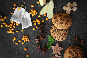Fresh tea ingredients with biscuits on grey background
