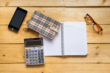 Papernote with mobile, eyeglasses and calculator on the wood tab