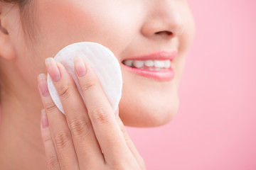 Naklejka premium Gorgeous young woman holding cotton pad and smiling in taking ca