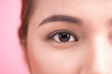 Beautiful asian woman eye with long eyelashes isolated on pink b