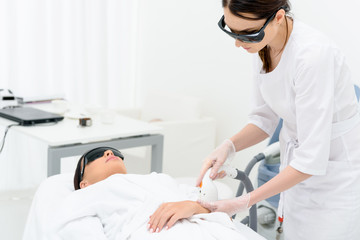 Skillful cosmetician making skincare ultrasound treatment