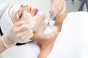 Obraz na płótnie Canvas Professional beautician treating female skin by foam
