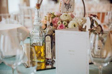 Mirror tray with big bouquet and bottles with drinks stand on th