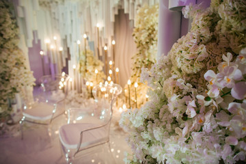 White flower garlands hang from the wall behind the stand full o