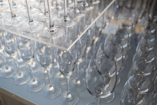 Sparkling wingeglasses stand under the glass tray with champagne
