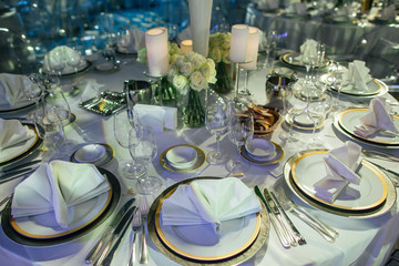 White dinner table festive served and decorated with white roses