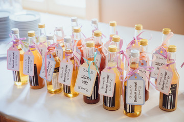 Little bottles with cards 'Drink me' stand on a white buffet