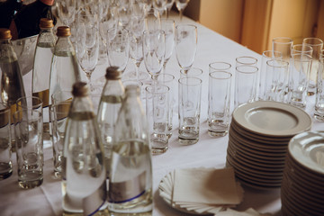Empty glassware stands on the table behind the crockery