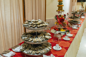 Tasty mussels stand on the tray behind the exotic fruits