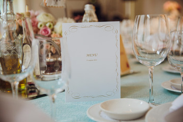 White menu card stands on the mint tablecloth