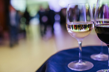 A look throught the glass with white wine on a hall full of gues