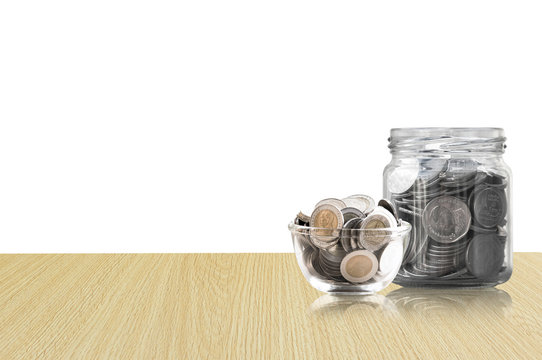 coins in a glass jar on Wood floor ,savings coins - Investment And Interest Concept saving money concept, growing money on piggy bank. isolated on white background