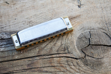 Blues harmonica music instrument on a old wood background - obrazy, fototapety, plakaty