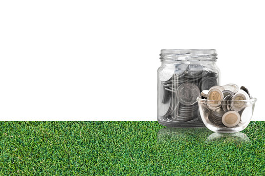 coins in a glass jar on grass floor ,savings coins - Investment And Interest Concept saving money concept, growing money on piggy bank. isolated on white background