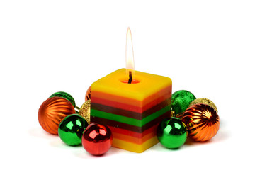 Christmas composition with burning candle and colored balls.