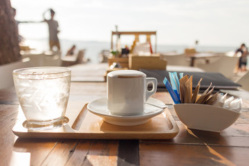 Coffee  cappuccino hot, water and cold morning sun.
