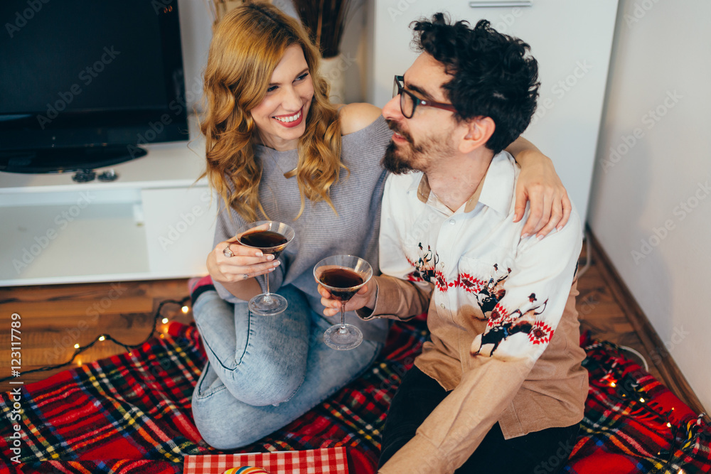 Sticker Young couple toasting with cocktail glasses at home