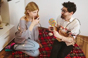 Young couple toasting with cocktail glasses at home