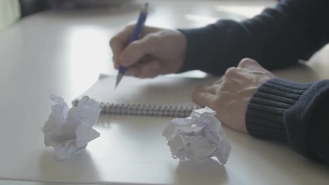 Man writing ideas on paper and are not satisfied and crumple paper