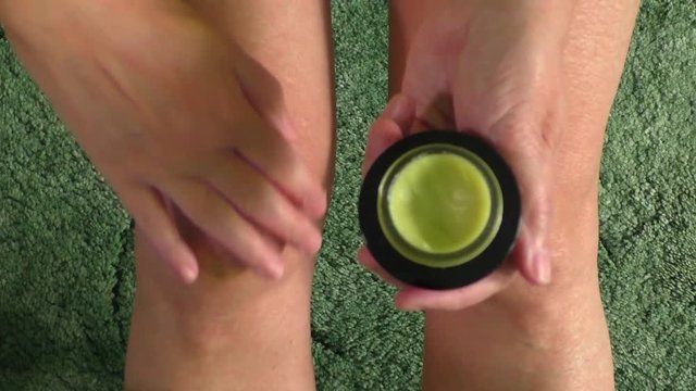 Woman putting ointment cream on bad injured knee. Sport training gym and health care  
