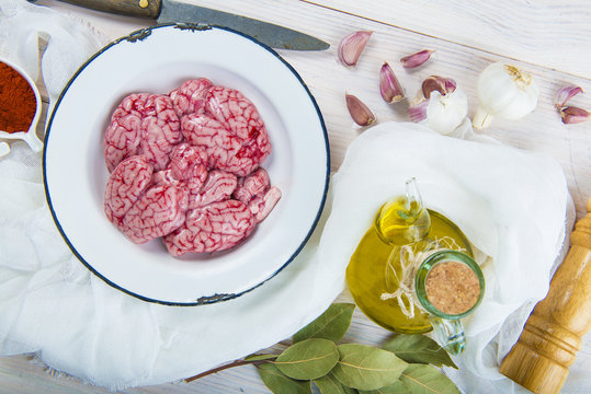 Sesos de cordero crudos con aceite de oliva virgen extra y otros ingredientes para cocinar
