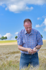 Ackerbau - Bauer pr&uuml;ft Qualit&auml;t des Getreides