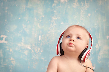 Baby mit Kopfhörern lauscht interessiert der Musik