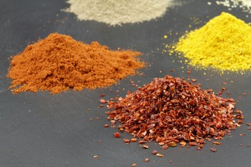 Various spices , red pepper flakes, grounded red pepper, curry, milled sort pepper 