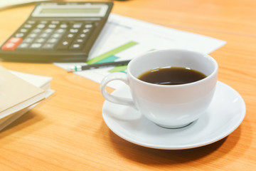 Digital tablet and cup of coffee on old wooden desk
