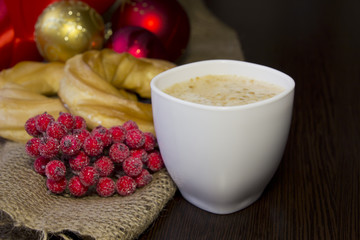 Cup of latte,red berries and  eclairs on the wooden background