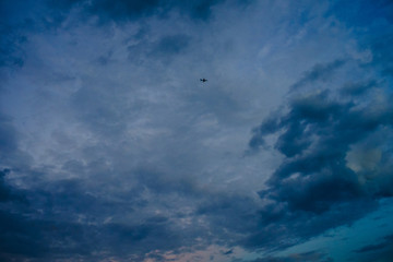 Obraz premium Flugzeug im dramatischen, wolkenverhangenen Abendhimmel