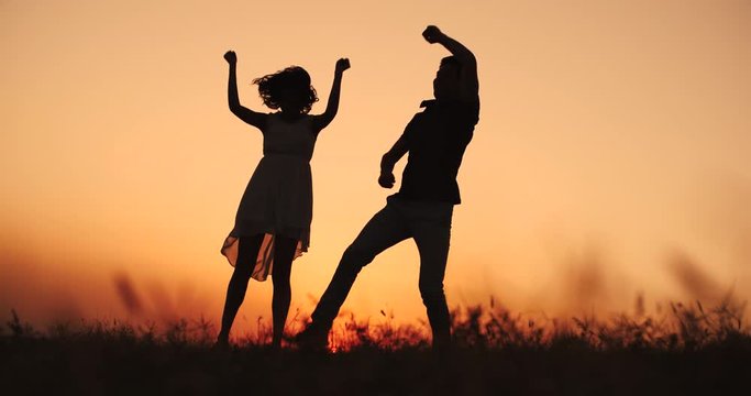 young happy couple having fun dancing on the sunset