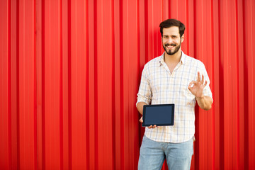 smiling man with tablet on background