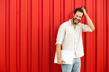 man with laptop on red background