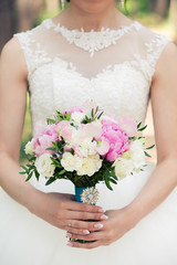 Obraz na płótnie Canvas the bride holds a bouquet in hand
