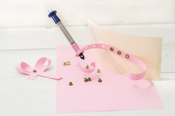 tool to insert eyelets and pink ribbon