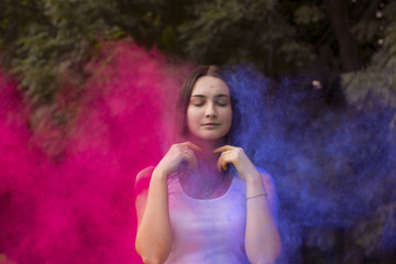 Pretty woman with colored powder exploding around her