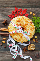 Winter holiday rustic background with peanuts tart and cinnamon. Christmas and New Year decorations. Tasty dessert with colorful ribbon. Top view, flat lay, place for text.
