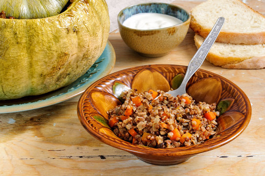 Tasty autumn stuffed pumpkin with buckweat and mushrooms
